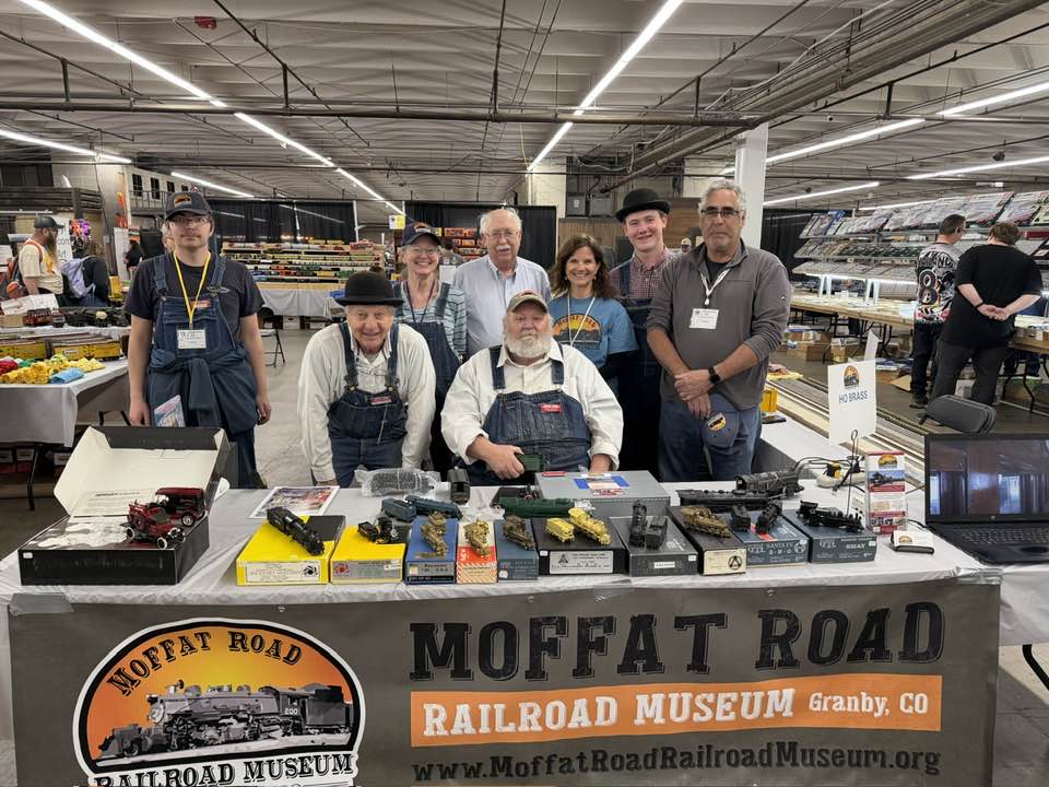 Moffat Road Railroad Museum volunteers behind a display table of model trains with the museum banner