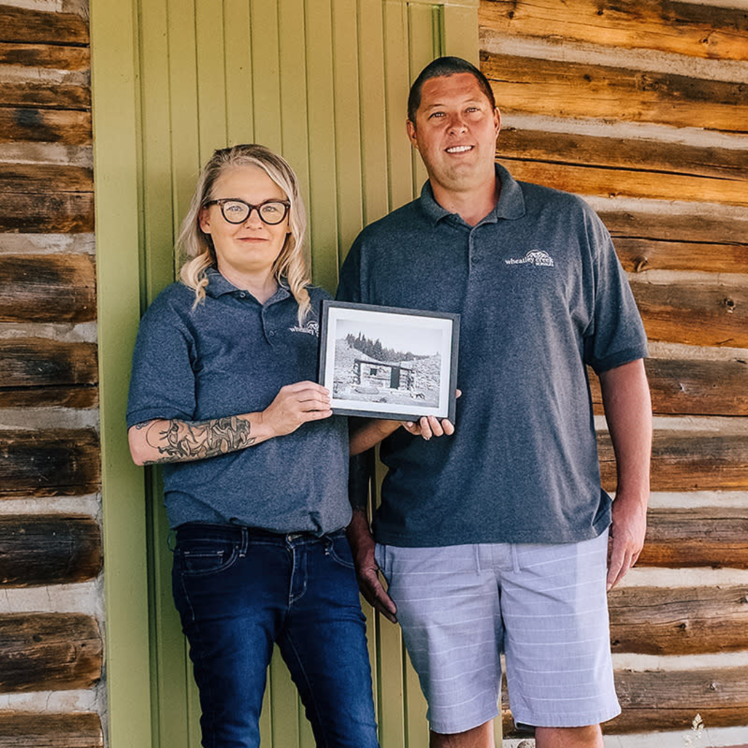 Wheatley Creek Services owners on the porch of a historic Granby Colorado log cabin